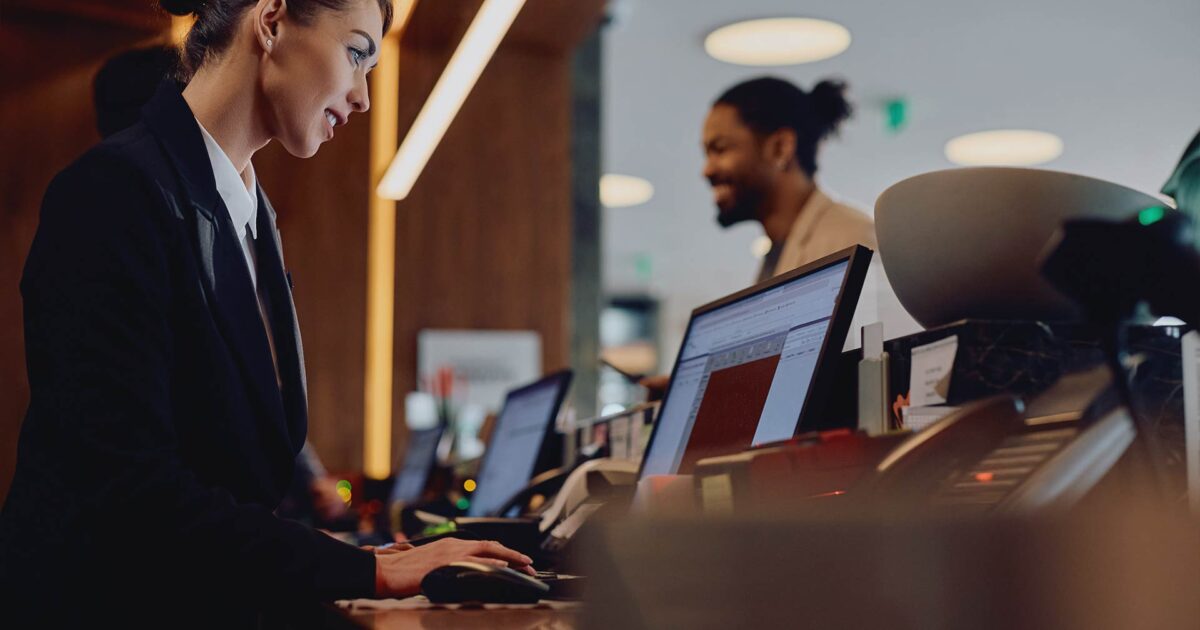 Woman at a computer, assisting customer in office setting, representing managed it services in NYC.