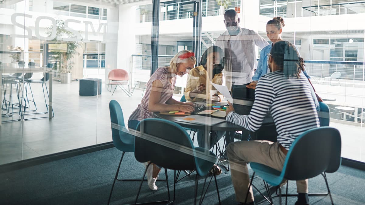 Small business team meeting in a modern office, discussing data backup and disaster recovery planning