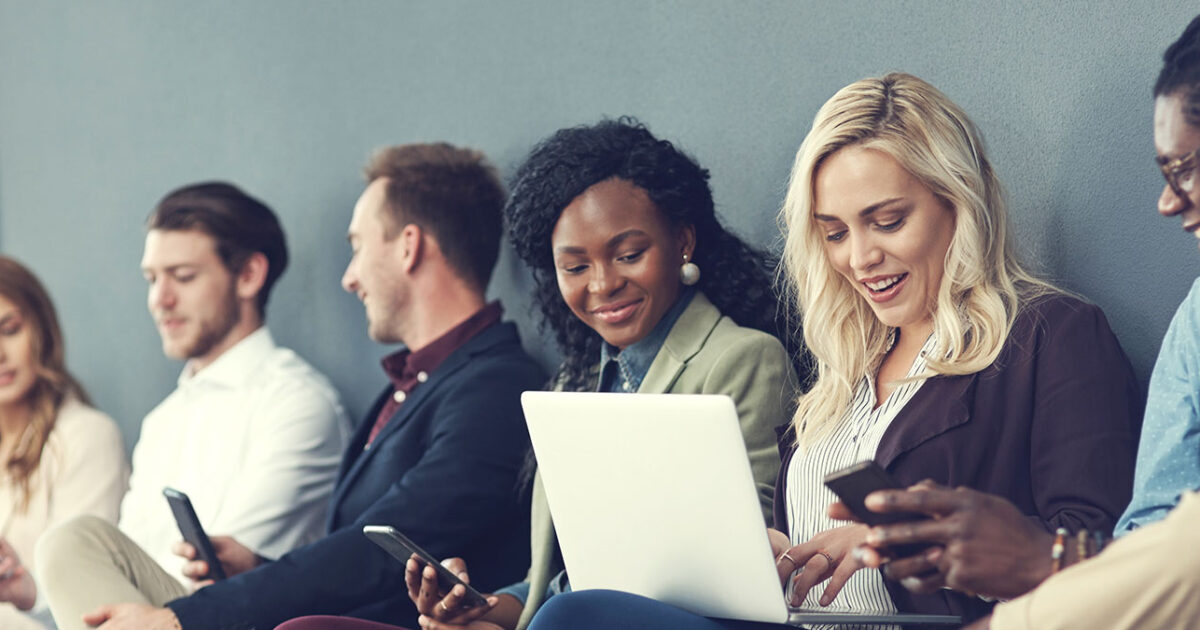 Office team using laptops, tablets, and smartphones during a Microsoft 365 email migration