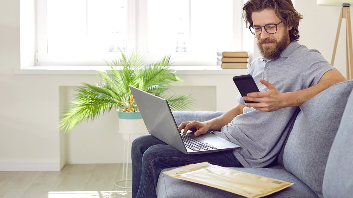 Business professional using a laptop and smartphone during a Microsoft 365 Outlook migration