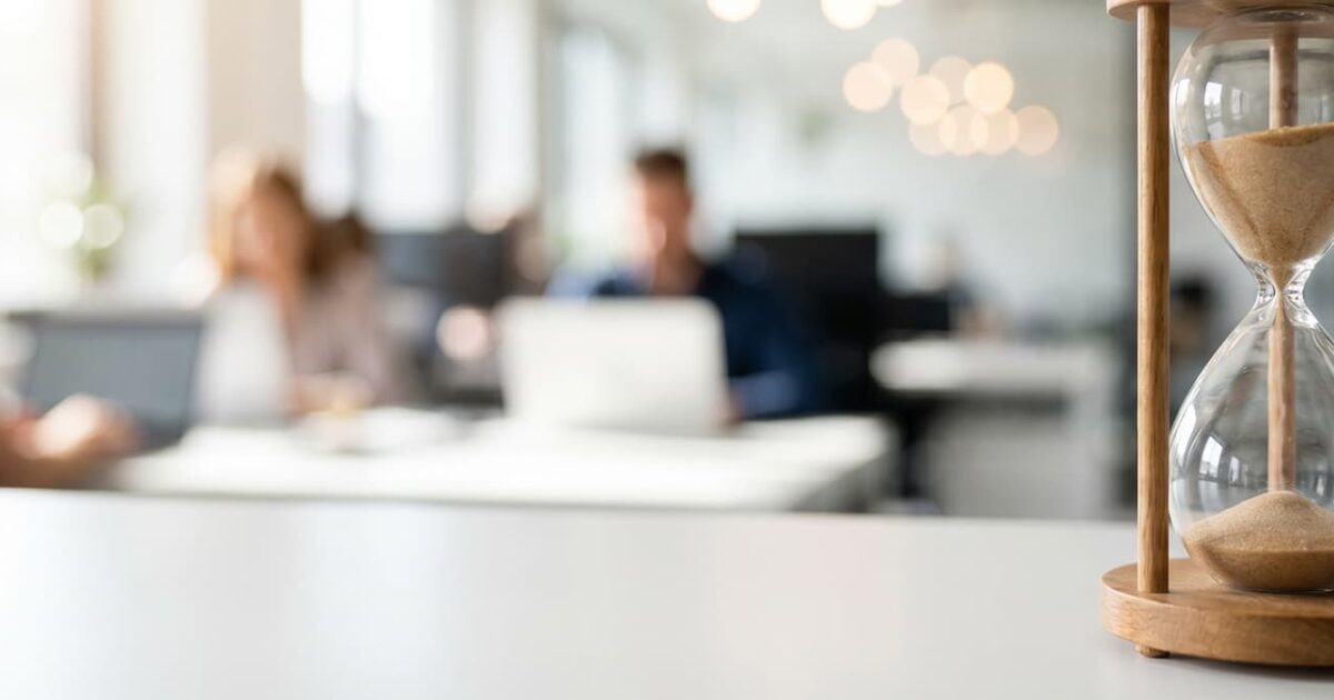 Hourglass in a modern office representing cutover timing and reduced Office 365 migration downtime.