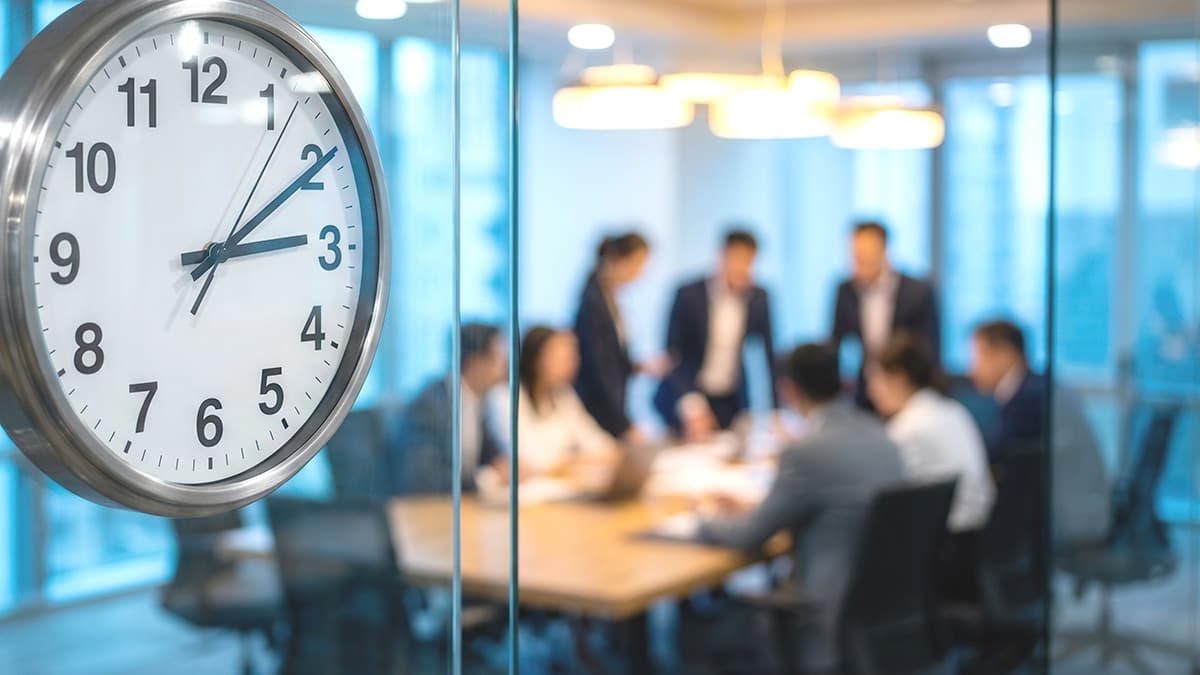 Large office clock beside a business team planning an Office 365 migration.